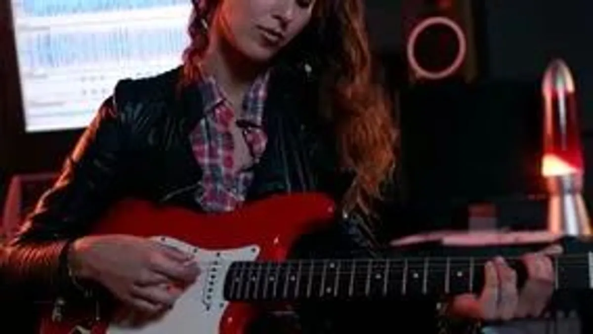 mulher tocando guitarra estudio