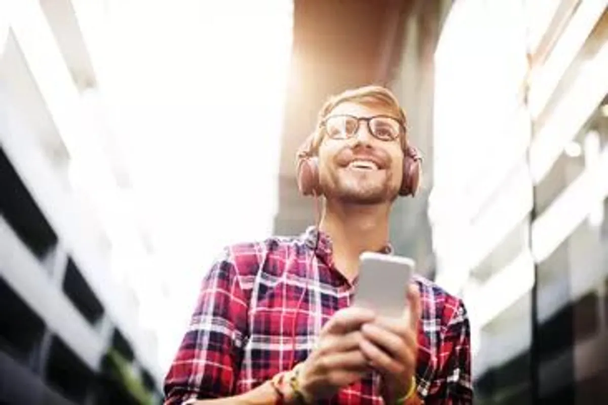 homem feliz ouvindo musica camisa xadrez