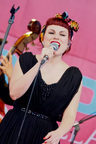 mulher ventindo preto fundo rosa cantando microfone sm58