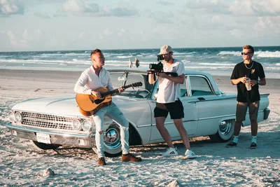 tres homens gravando clipe carro praia