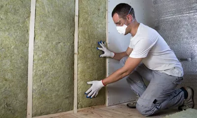 homem instalando isolamento acustico parede drywall 