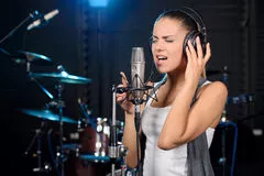 jovem mulher cantando estudio escuro