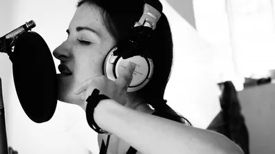mulher cantando microfone headphone preto e branco olhos fechados
