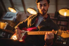 homem jovem tocando guitarra bar