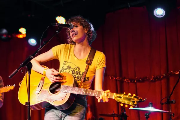 mulher tocando guitarra amarelo